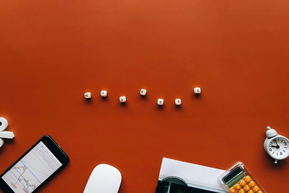 Top view of mobile payment setup with smartphone, credit cards, and laptop on pink background.